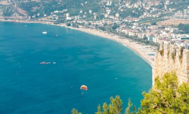 A breathtaking aerial view of Alanya's coastline with lush hills and a vibrant sea.